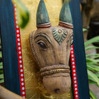 Wooden wall art of a bull's head with decorative elements on a gold background