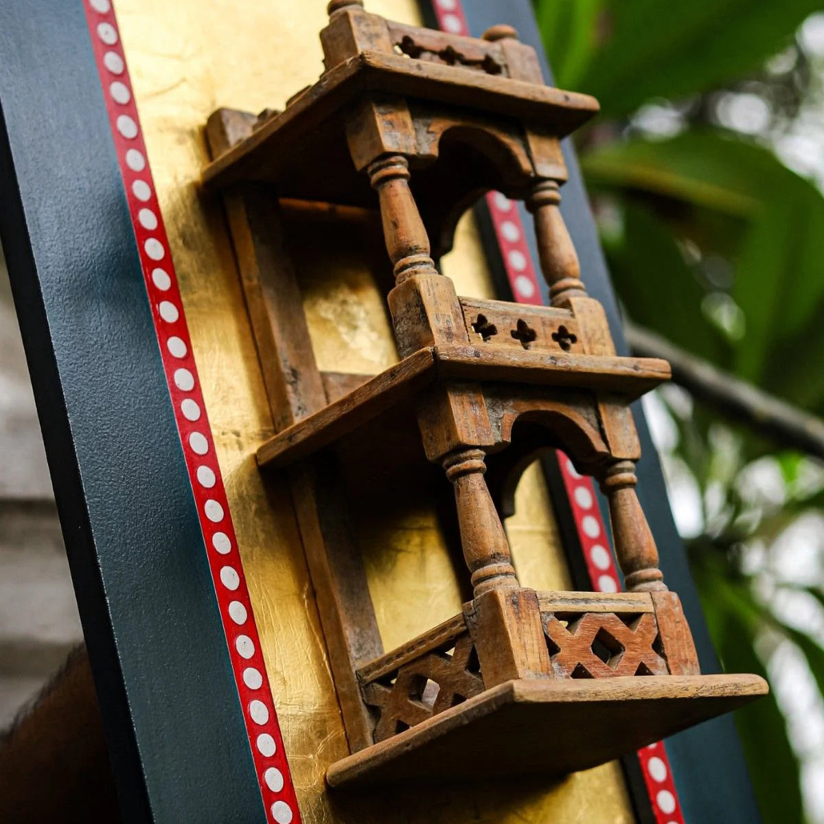 Wooden decorative shelf with intricate carvings on a framed background