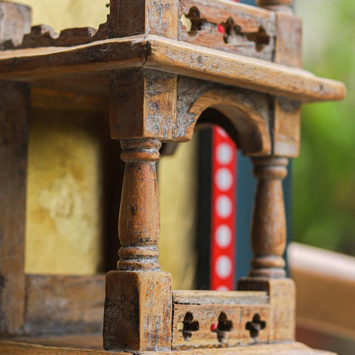 Close-up of an ornate wooden structure with intricate carvings, blurred background.