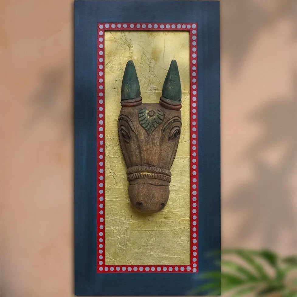 Wooden sculpture of a horse head with green eyes on a textured wall panel.