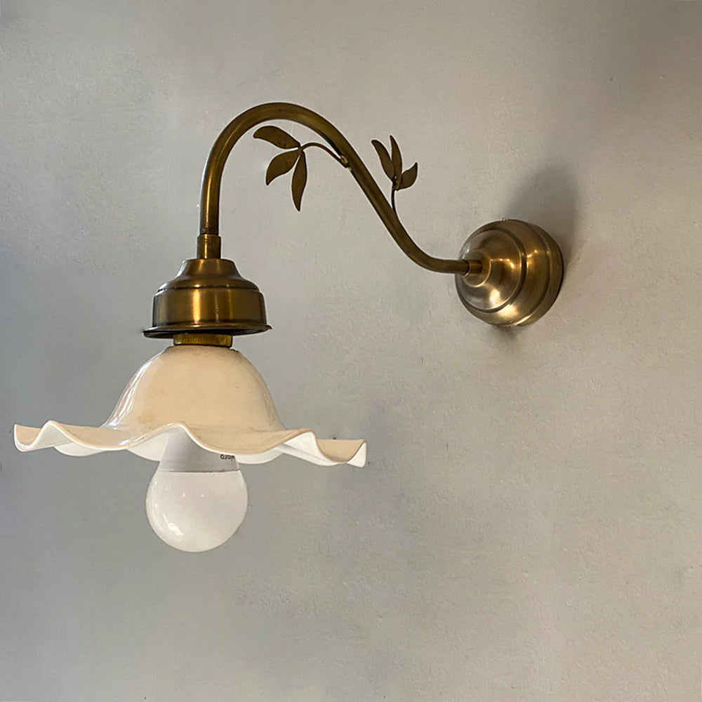 Wall-mounted light fixture with floral design on a plain wall