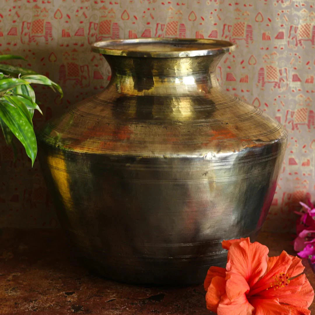 Brass pot with floral decorations on a patterned background