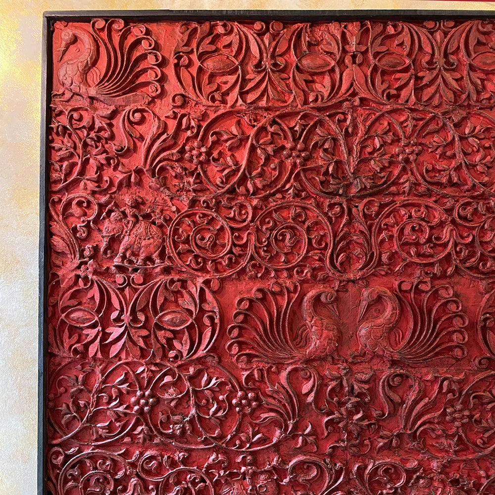Red textured wall panel with intricate patterns on a light background