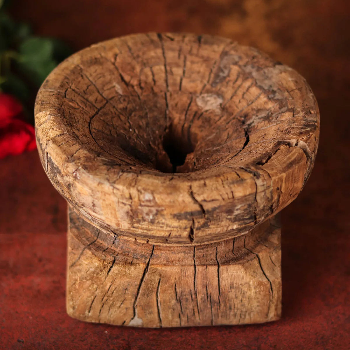 Wooden mortar and pestle on a red background