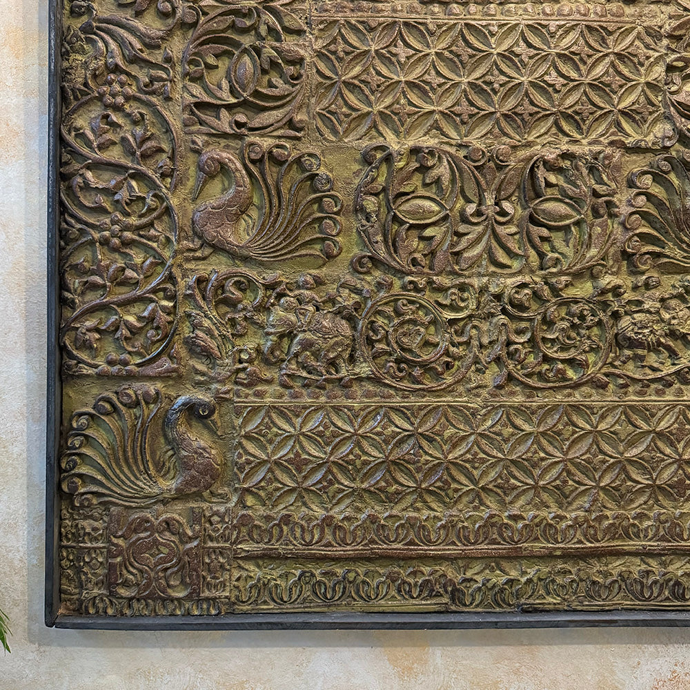 Decorative stone panel with intricate carvings of birds and geometric patterns.