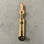 Wooden ladle with black spoon on a gray concrete background
