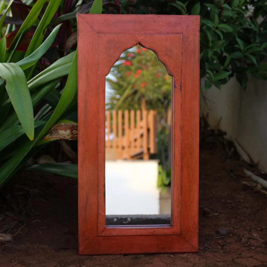Wooden mirror with decorative frame on a garden path