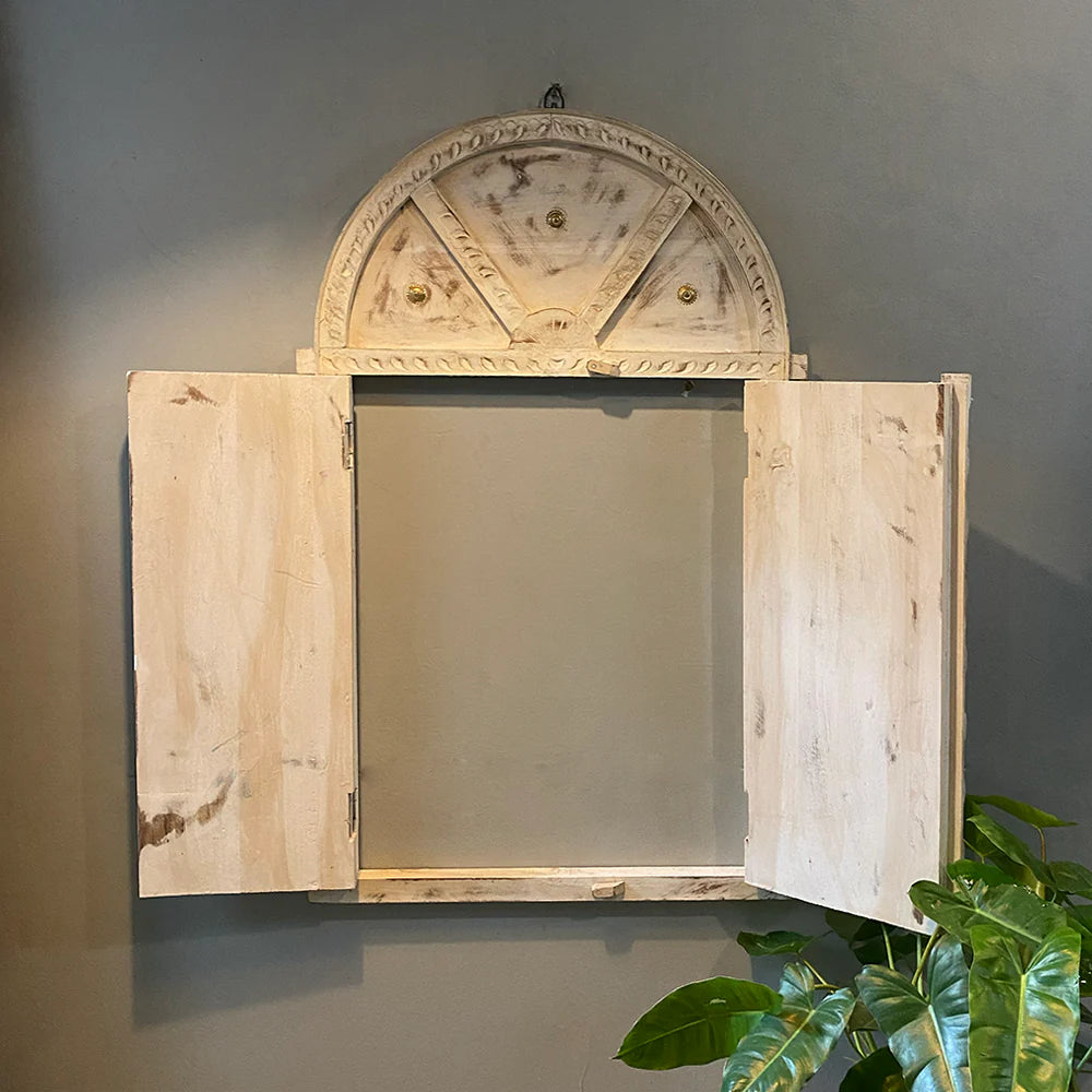 Decorative wooden mirror with open doors on a gray wall