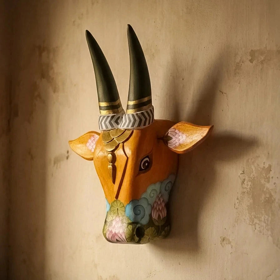 Decorative wall-mounted animal head with painted features on a textured wall.