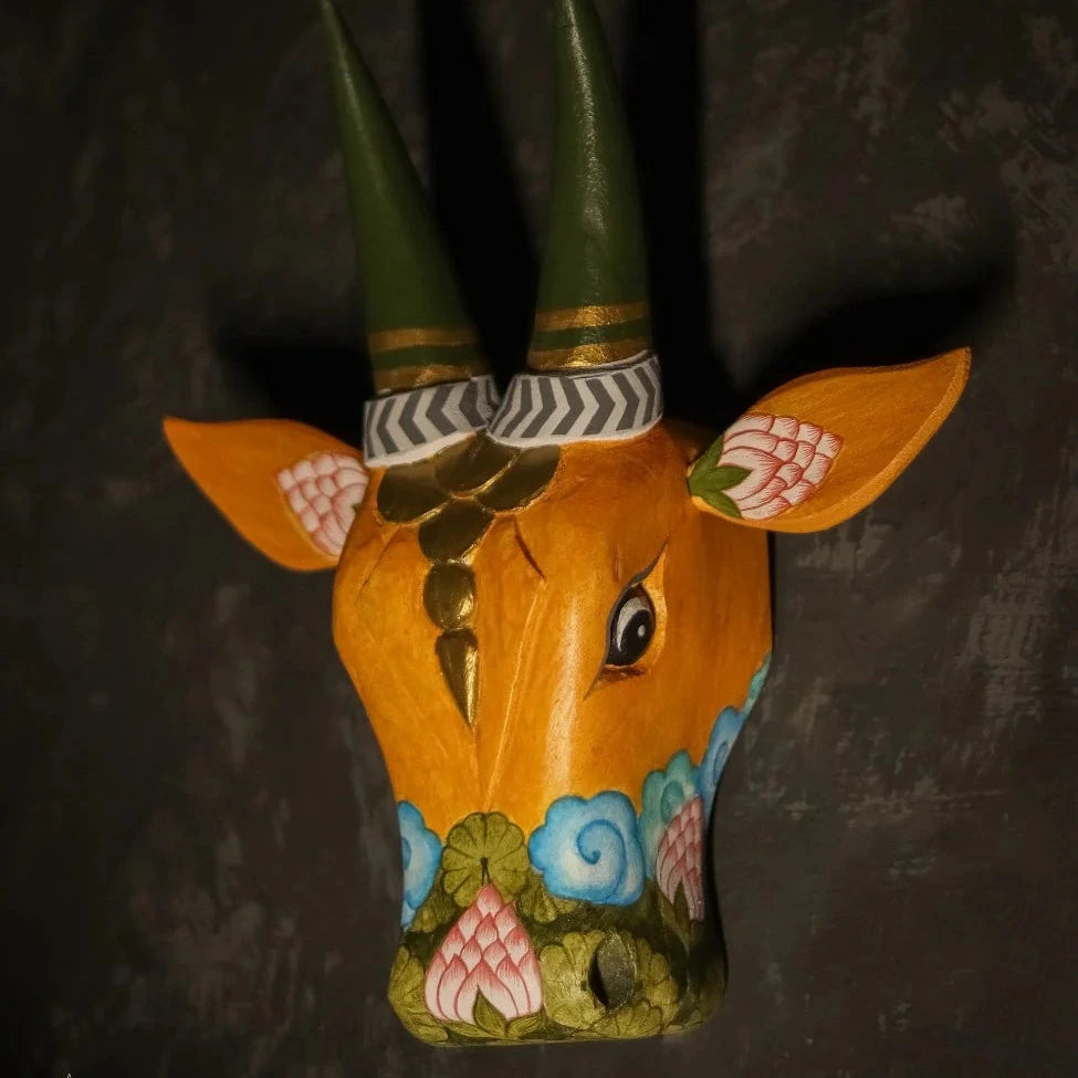 Decorative wall art of a bull's head with colorful patterns on a dark background